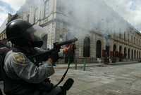Agente de la PFP lanza gas lacrimgeno a integrantes de la APPO durante el enfrentamiento del pasado 20 de noviembre en Oaxaca